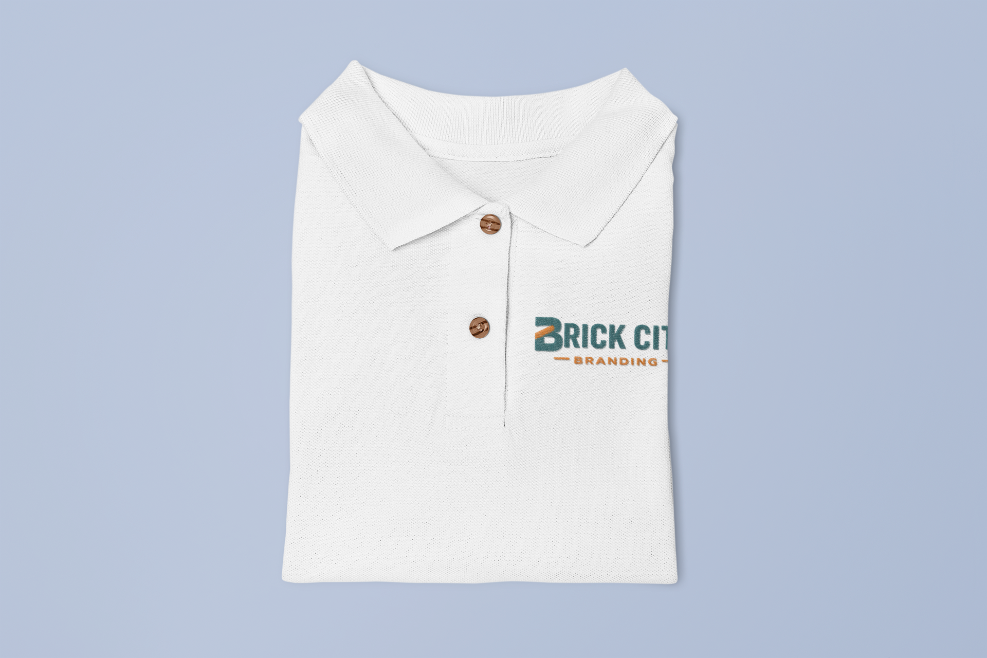 A neatly folded white polo shirt with custom branding embroidered on the chest, showcasing custom embroidered polo shirts in San Diego, CA.