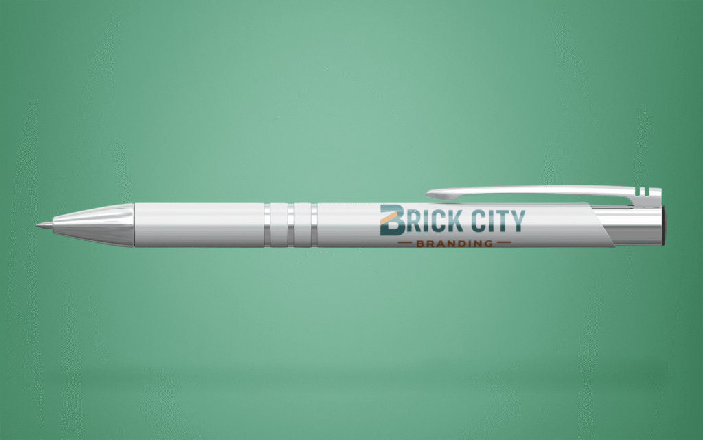 A white metal pen with a full-color Brick City Branding logo imprinted on the barrel, featuring chrome accents and a matching silver clip.