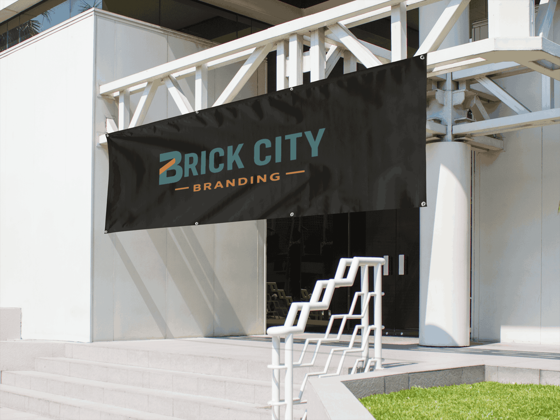Large black custom vinyl business banners for Brick City Branding hanging on a white modern building exterior.