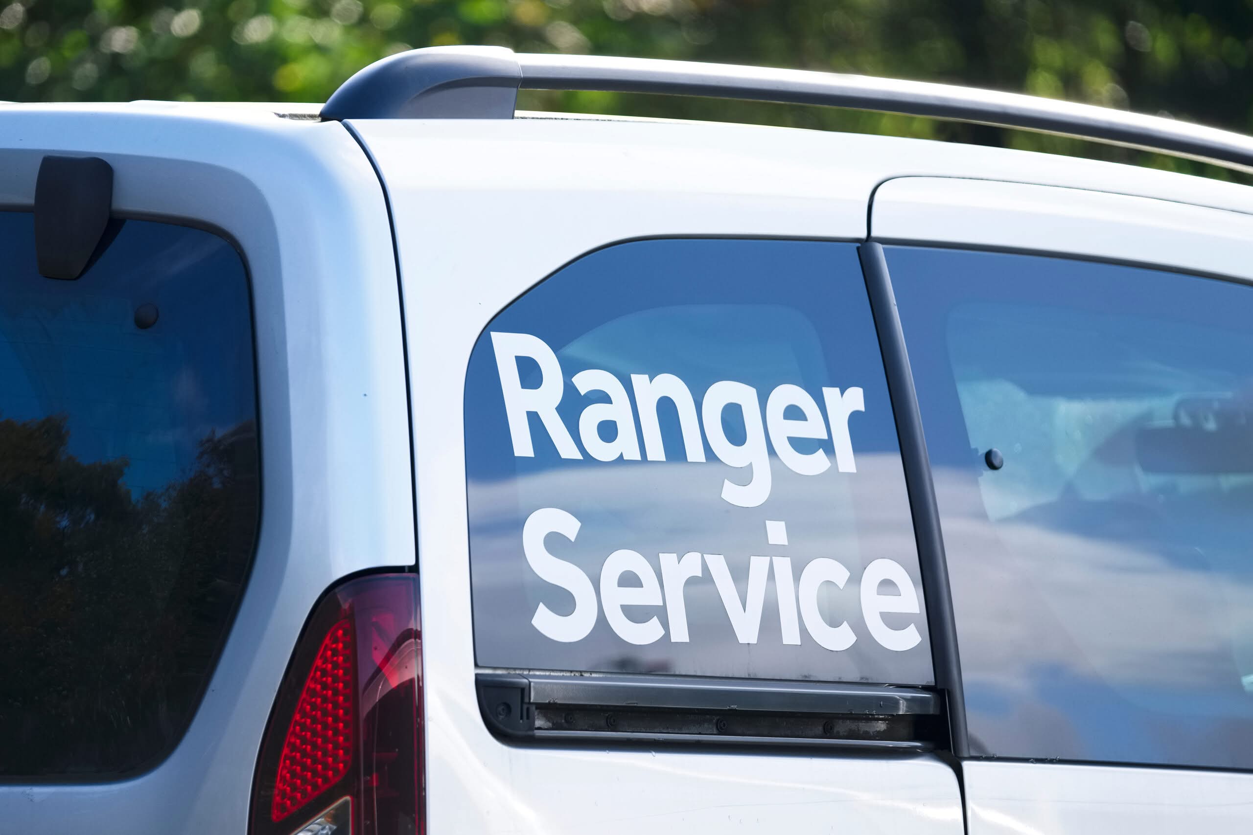 White vinyl lettering reading Ranger Service on a work vehicle's rear window