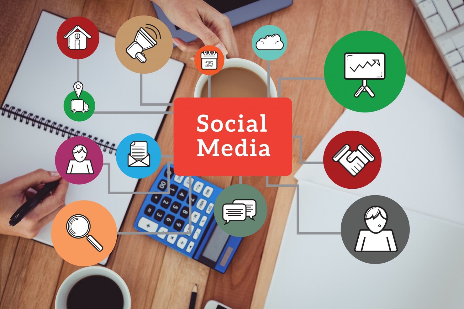 A top-down view of a desk with a notebook, coffee, calculator, and graphic icons surrounding a red social media label, representing a social media marketing agency in Austin, TX.