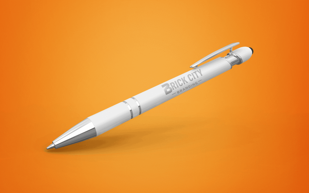 A premium white metal pen with the Brick City Branding logo laser-engraved on the barrel, featuring chrome accents and a black stylus tip against a vibrant orange background.